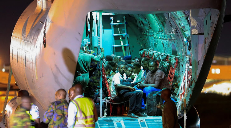Evacuees from war-torn Sudan sit inside a military plane as they wait to be processed by members of the Kenya Defence Forces upon their arrival at the Jomo Kenyatta International Airport in Nairobi, April 24, 2023.