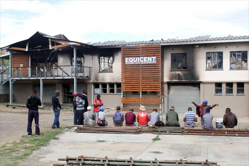 BURNING THEIR FUTUREThe Equicent Infrastructure Development building had millions of rands worth of equipment and tools destroyed when it was burnt down, apparently due to a protest over safety concerns at the campus. About 30 plasma TVs, washing machines, computers, beds, stoves, chairs, beds, and maintenance tools, were among the items that were burnt to ashes. Staff sit outside the burnt building Picture: ASANDA NINI