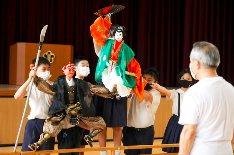 Kozu elementary school students perform a traditional puppet drama in front of Kanjuro Kiritake, a Bunraku puppeteer, during a class by Kanjuro amid the coronavirus disease outbreak, in Osaka, western Japan on August 28 2020.