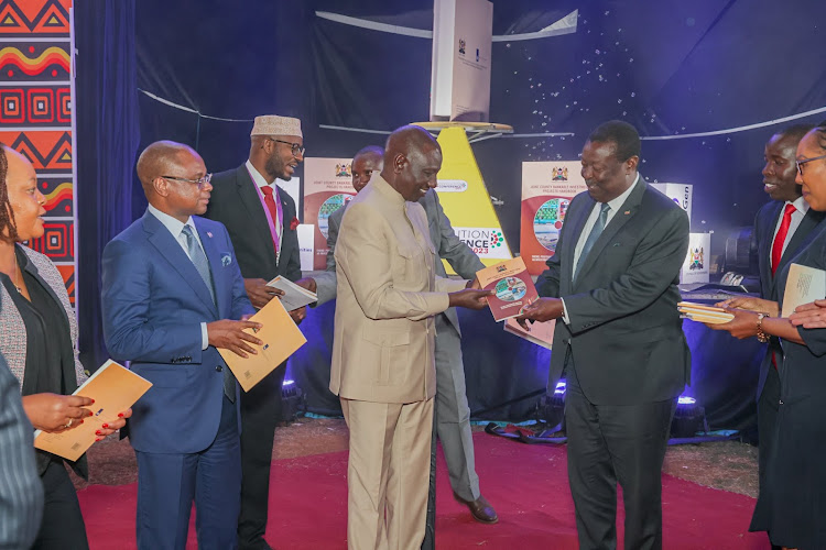 President William Ruto and Prime CS Musalia Mudavadi share a moment at the 8th Devolution conference.