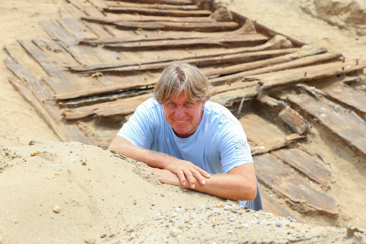 Miomir Korac, lead archaeologist, poses for a picture in front of the hull of a wooden ship, an ancient Roman flat-hulled riverine vessel at the ancient city of Viminacium, near Kostolac, Serbia, August 2, 2023.