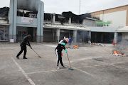 Members of the community come out in numbers to help with clean-up operations after the days of looting and rioting in the area in Vosloorus, east of Johannesburg. 