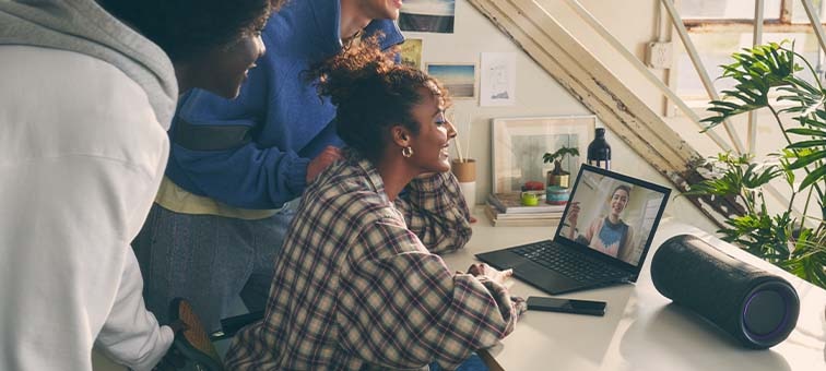 Image of people surrounding a laptop and the SRS-XG300 X-Series Portable Wireless Speaker