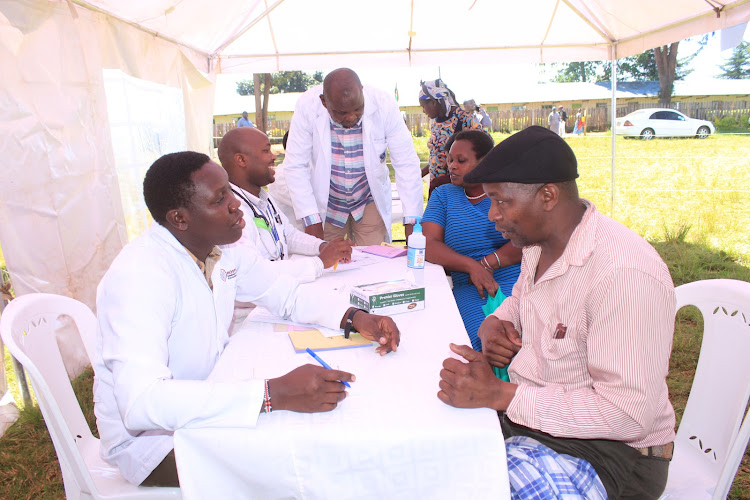 KNH doctors treating patients during a free medical camp at Kiria-ini Catholic church in Mathioya, Murang'a county, on Friday.