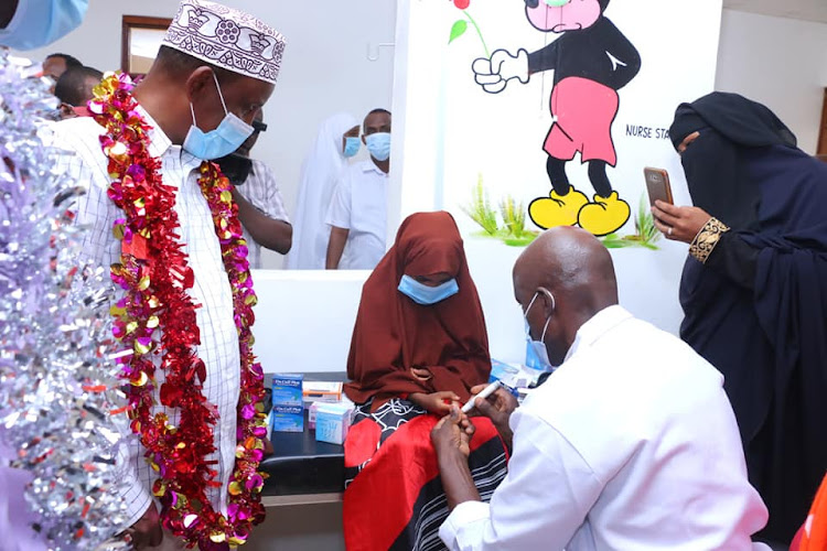 Dr Ambroce Misore runs a blood sugar test on Sabrin Salah, 8. Looking on is Garissa Governor Ali Korane.