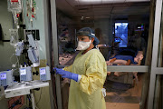 Sabrina Stewart, registered charge nurse of the Intensive Care Unit, prepares to enter the room of a coronavirus disease (Covid-19) patient in their isolation room on the Intensive Care Unit (ICU) at Western Reserve Hospital in Cuyahoga Falls, Ohio, US, January 4, 2022. 