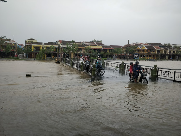 People make their way through floodwater in the aftermath of Typhoon Noru in Hoi An, Vietnam September 28, 2022 in this picture obtained from social media.