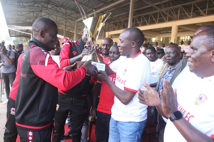 Shabana captain George Onyango hands over the NSL trophy to Kisii Governor Simba Arati