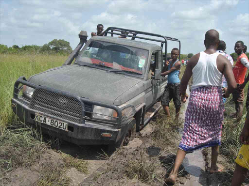 Residents of Milimani in remote part of the Boni forest try to look for a way to pull out a vehicle that had been stuck in the mud in the bad terrain. Photo/Alphonce Gari