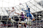 Burnley's Jay Rodriguez heads the ball under pressure from West Ham's goalkeeper Lukasz Fabianski and defender Craig Dawson at London Stadium on April 17, 2022