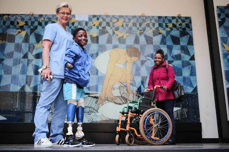 From left: Prosthetist Marissa Nel, George Masiu and his mother Angelina pose for a picture after receiving prosthetic legs at the Johannesburg City Council building in Braamfontein, Johannesburg. Rand Mutual (RMA) donated prosthesis to Masiu as part of the City of Johannesburg’s Disability Awareness campaign. Masiu had his limbs amputated after he contracted a rare degenerative disease.