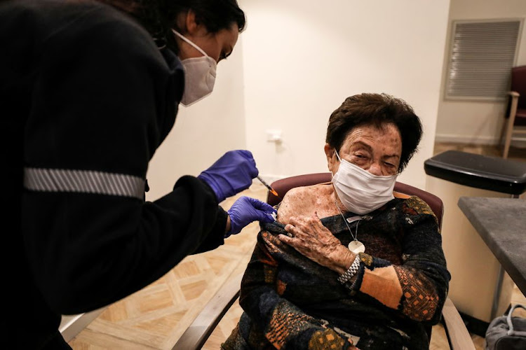 89-year-old Yodit Ben Ari receives a fourth dose of the coronavirus disease (COVID-19) vaccine following a vaccination party after Israel approved a second booster shot for the immunocompromised, people over 60 years and medical staff in a retirement home in Netanya, Israel January 5, 2022.