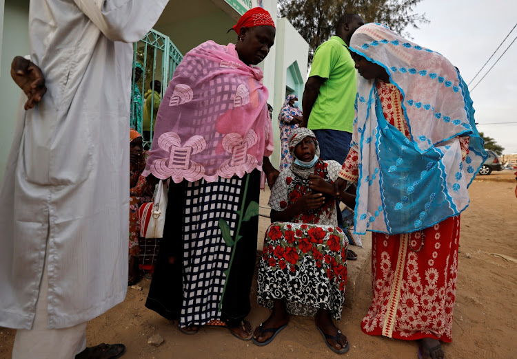 Diali Kaba, a mother of a ten-day-old baby, reacts as she is comforted by her mother Ndeye Absa Gueye, as she sits outside the hospital, where newborn babies died in a fire at the neonatal section of a regional hospital in Tivaouane, Senegal on May 26, 2022.