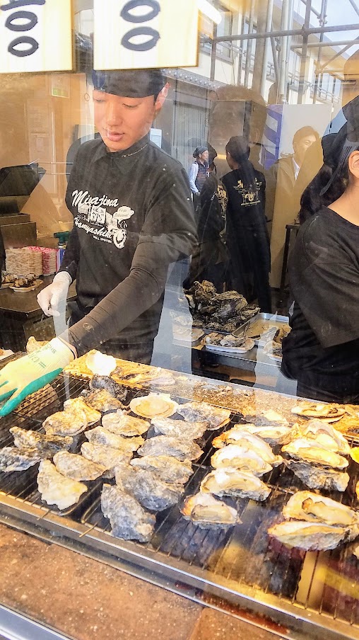 Hiroshima Day trip to Miyajima. The oysters in Hiroshima are famous, particularly the ones from Miyajima because there are many oyster farms located here for the past 400 years or so. You will see multiple stands offering quick grab and go raw or grilled oysters all along the streets.