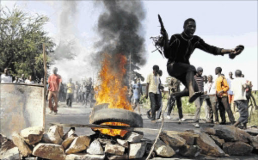 NO WAY: A youth jumps over a barricade during clashes between protesters and riot police in Bujumbura yesterday. Hundreds marched in a third day of protests against President Pierre Nkurunziza's decision to run for a third term, a move critics say violates the constitution PHOTOs: Thomas Mukoya/REUTERS