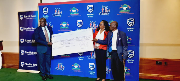 Stan-Bic Bank Chief Executive, Charles Mudiwa hands over a dummy Sh10 Million dummy cheque to Nakuru Governor Susan Kihika and Athletics Kenya, South Rift branch chairperson, John Wachira.