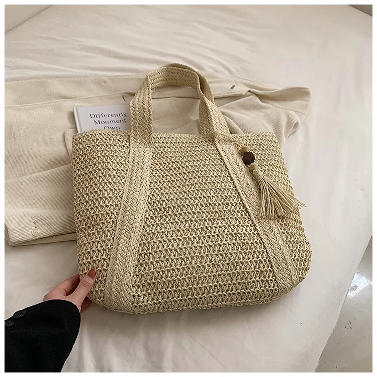 Bolsa feminina casual de praia com alça de ombro, palha e pingente de mogno, perfeita para um look fashion e leve.