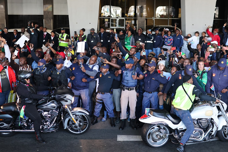 Police hold back crowds as the women's soccer team champions return to SA.