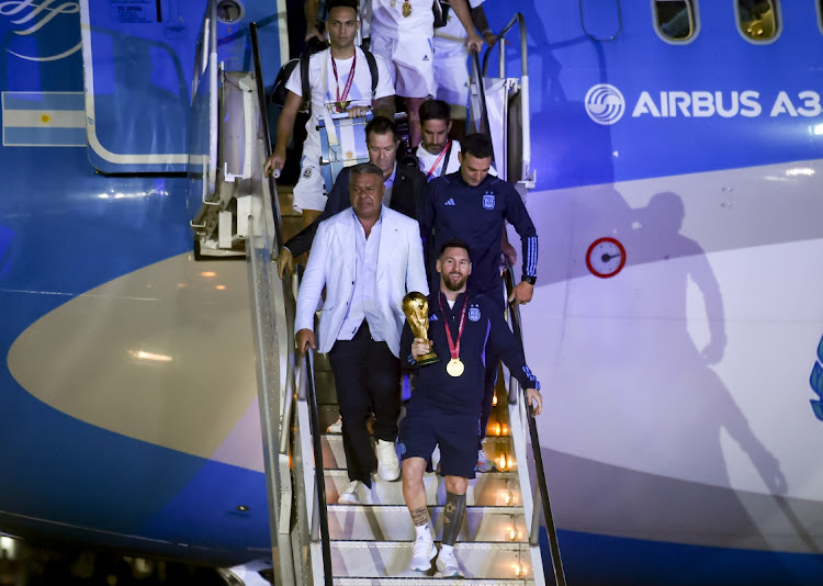 Argentina stars Lionel Messi, Claudio Tapia and coach Lionel Scaloni exit their plane with Fifa World Cup trophy on the arrival of the Argentina team in Buenos Aires on December 20 2022. Argetina won 2022 World Cup in Qatar by beating France on penalties in Sunday's final.