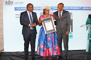 The principal of Waterkloof Primary, Sarah Monyai, receives the Kadar Asmal Lifetime Achievement Award. With her are Gauteng education MEC Matome Chiloane and HOD Edward Mosuwe. 