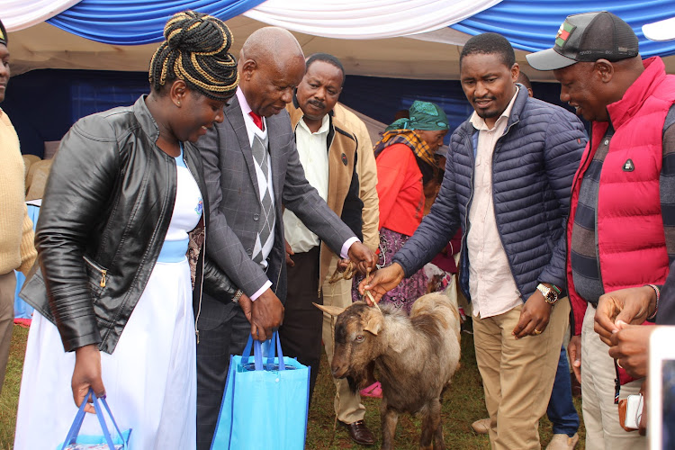 The dairy chairman Muhika Mutahi (2nd left) presentS gifts to CS Mwangi Kiunjuri (2nd right) during the dairy’s AGM at Kiriti stadium in Mukurweini town on Friday