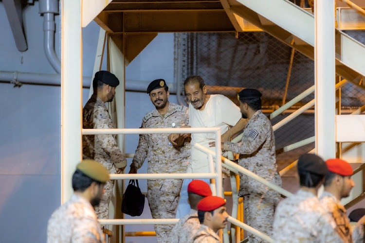 Saudi Royal Navy personnel assist a man who was evacuated by the Saudi navy from Sudan, in Jeddah, Saudi Arabia, April 24, 2023.