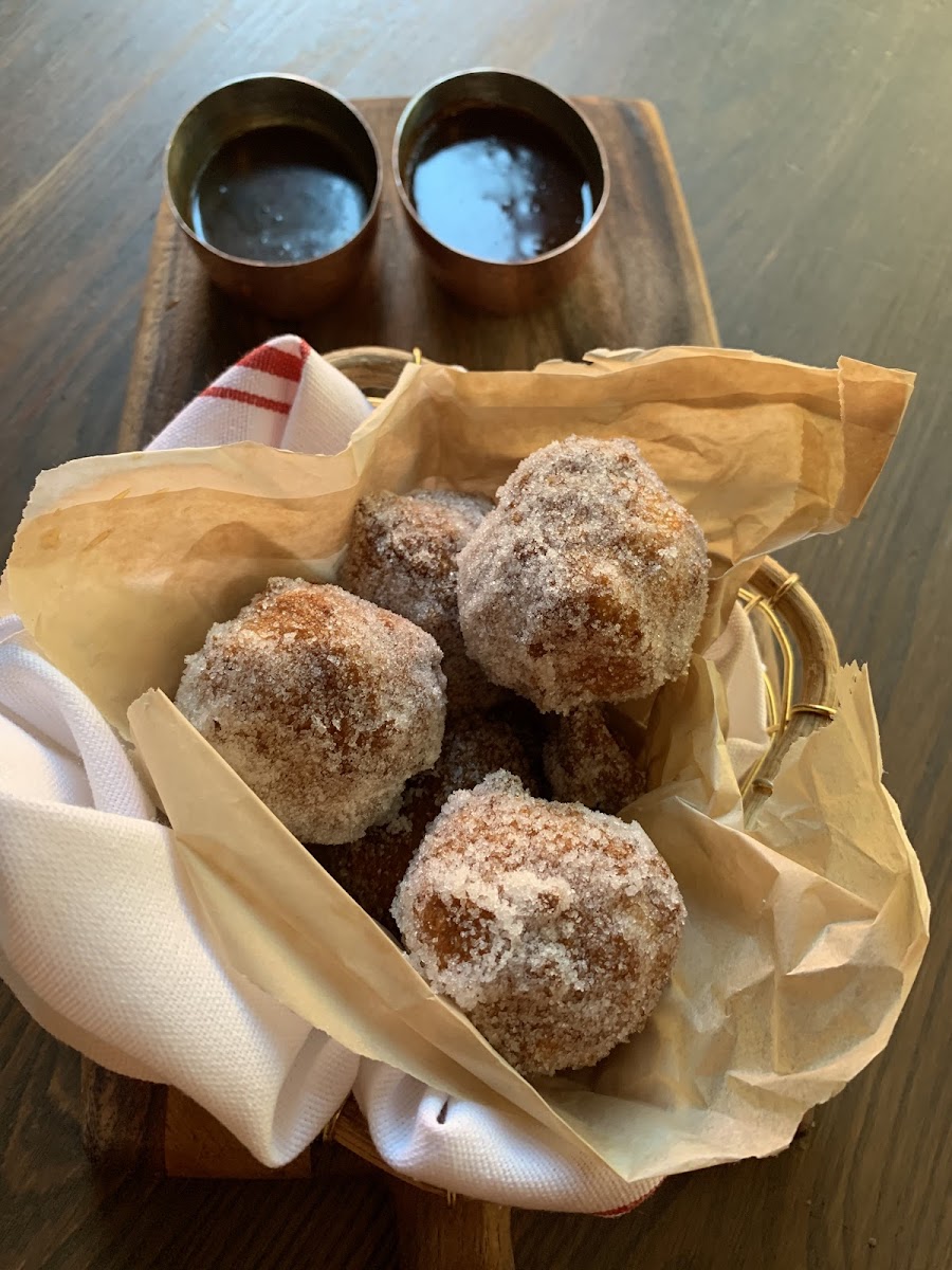 Raised gluten free donuts with chocolate and caramel dipping sauces