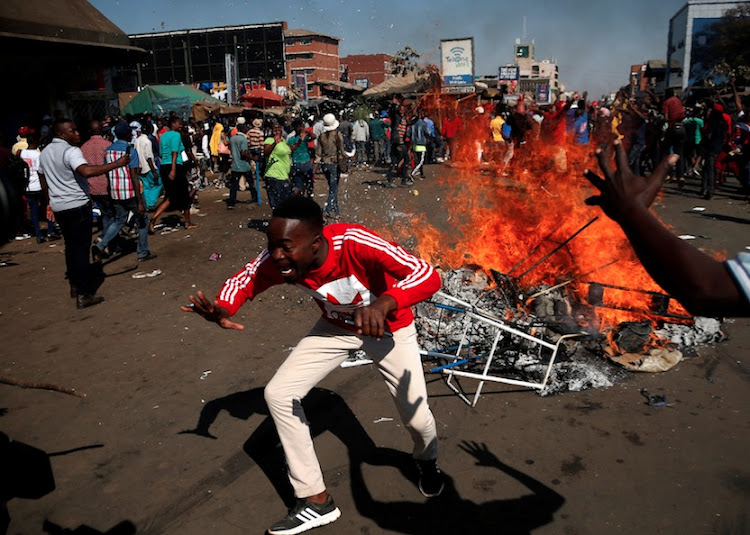 Supporters of the opposition Movement for Democratic Change party (MDC) of Nelson Chamisa react as they block a street in Harare, Zimbabwe, August 1, 2018.