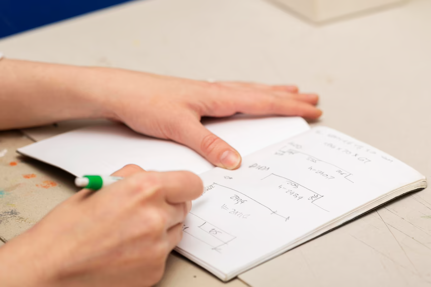 A focused woman writing measurements in a notebook, symbolizing dedication and organization in the CASPer study.