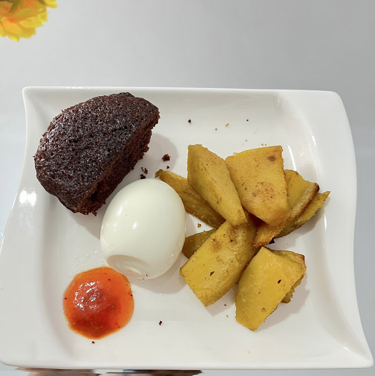 Oven baked sweet potatoes served with boiled eggs, a chocolate muffin and a side of hot and sweet sauce