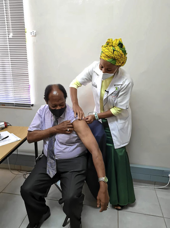 Limpopo health MEC Phophi Ramathuba prepares Bishop Barnabas Lekganyane of the Zion Christian Church for his Covid shot.