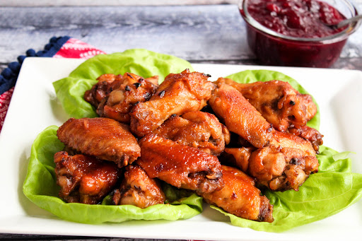 A platter of Cranberry Sweet Hot Wings with dipping sauce.