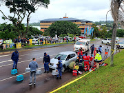 Paramedics treat a man who was shot multiple times outside a mall in Westville, Durban, on Friday.