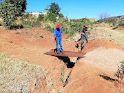 GaKgapane residents use a  makeshift bridge to cross an abandoned drainage trench. 