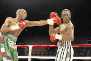 TAKE THAT: Takalani Ndlovu, right, takes   a punch from Jeffrey Mathebula during their IBF junior featherweight title fight at Carnival City in Ekurhuleni. Photo: Antonio Muchave