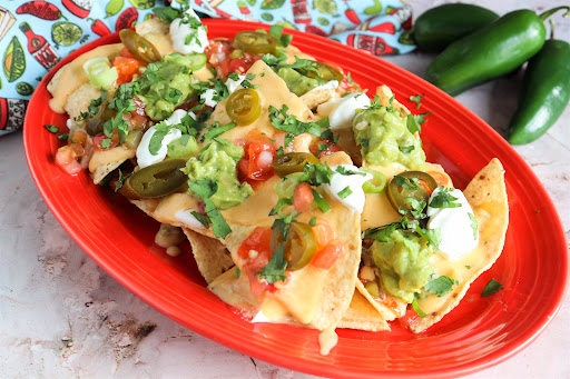 A platter of Ultimate Nachos With Homemade Cheese Sauce.