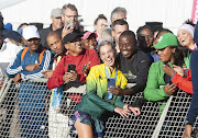 Gerda Steyn celebrates with spectators at the finish at UCT Rugby Fields after winning the 2023 Two Oceans Ultra Marathon in a new course record.