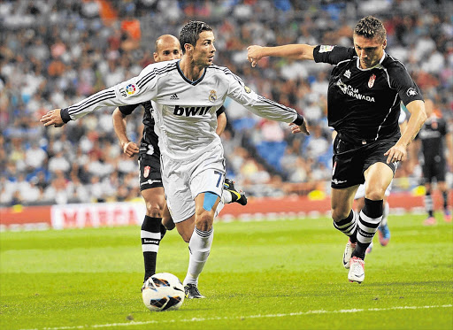 Cristiano Ronaldo, in white, scored two goals in Real Madrid's 3-0 victory over Granada in Madrid, Spain, on Sunday, but did not celebrate either, stating later he was unhappy at the club Picture: GONZALO ARROYO MORENO/GALLO IMAGES