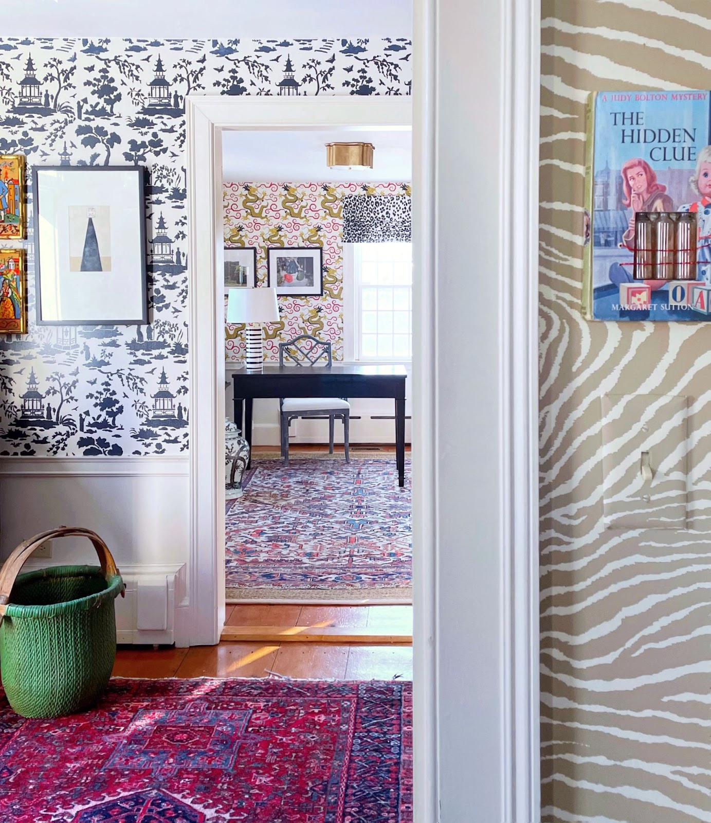 A variety of bold prints and patterns in wallpaper and carpets fill several spaces including a home office in the distance.