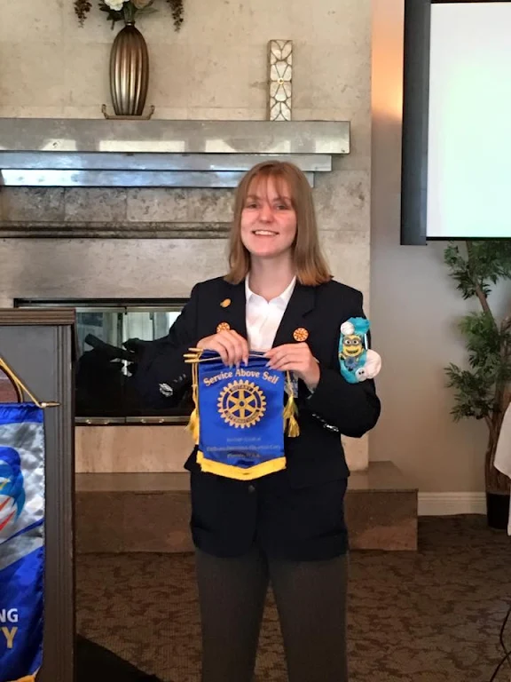 Photo: August 16, 2016 Guest Speaker Kayla Harshman is the Club's Outbound Rotary Youth Exchange Student. Kayla heads to Italy for Art School. She is holding the Club mini-banners and was also given traveling money.