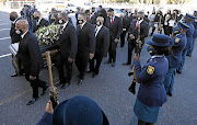 A police guard of honour presents arms as the coffin of Western Cape Gang Unit section commander Lt-Col Kinnear arrives with close family members at his funeral service in Cape Town yesterday.  Kinnear was shot outside his home.