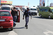 Police  inspect cars after taxi violence  flared up in some parts of Soweto.