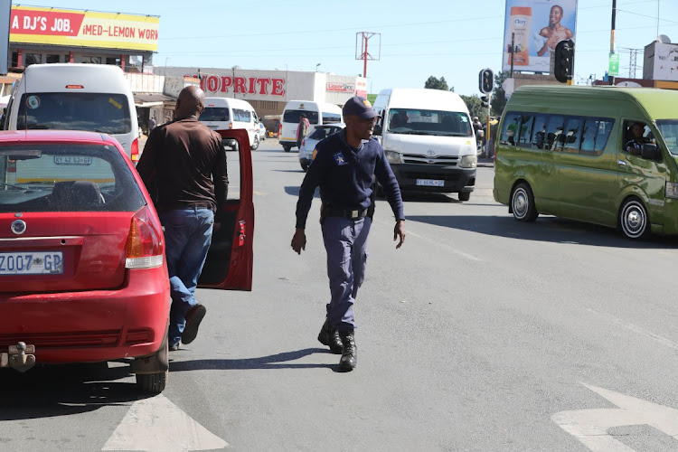 Police inspect cars after taxi violence flared up in some parts of Soweto.