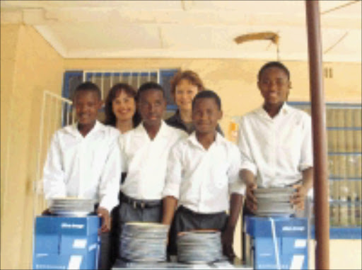 BETTER FUTURE: Kingsway's principal Angela de Lange and school secretary Debbie Hemmens with Grade 6 pupils Raymond Kgobe, Rocks Khoza, Moloka Magomola and Mathew Ndebele show off some of the gifts they received from Sowetan. 05/11/08. © Unknown.