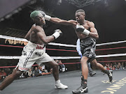 John Bopape (black trunks) forces Ricky Tshabalala to cover up in their bout which  Bopape  won by a stoppage in the second round in Benoni.