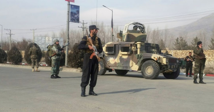 Afghan security forces keep watch at the site of an attack in Kabul, Afghanistan