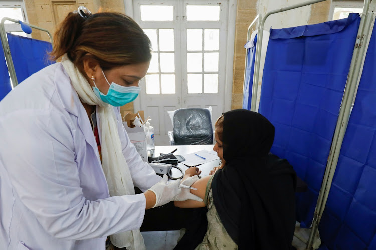 A health worker receives a dose of Sinopharm's coronavirus disease (Covid-19) vaccine, donated by China, at a vaccination centre in Karachi, Pakistan February 8, 2021.