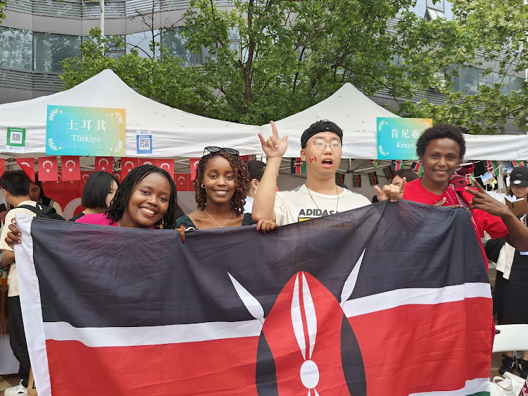 Kenyan Students in China Association president Wambui Kiarie (Peking University), Annette Munene (CFAU) and Peter Gikonyo (BLCU) with a Chinese student at the 19th World Cultural Carnival in Beijing, China.