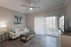 Furnished living room with wood plank flooring, a sliding glass patio door with blinds, and light gray walls