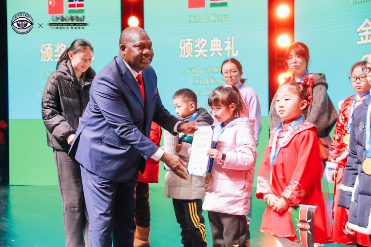 Education Attache Innocent Mogunde awards a participant of the China-Africa Children International Competition in Shanghai on Tuesday, January 23, 2024